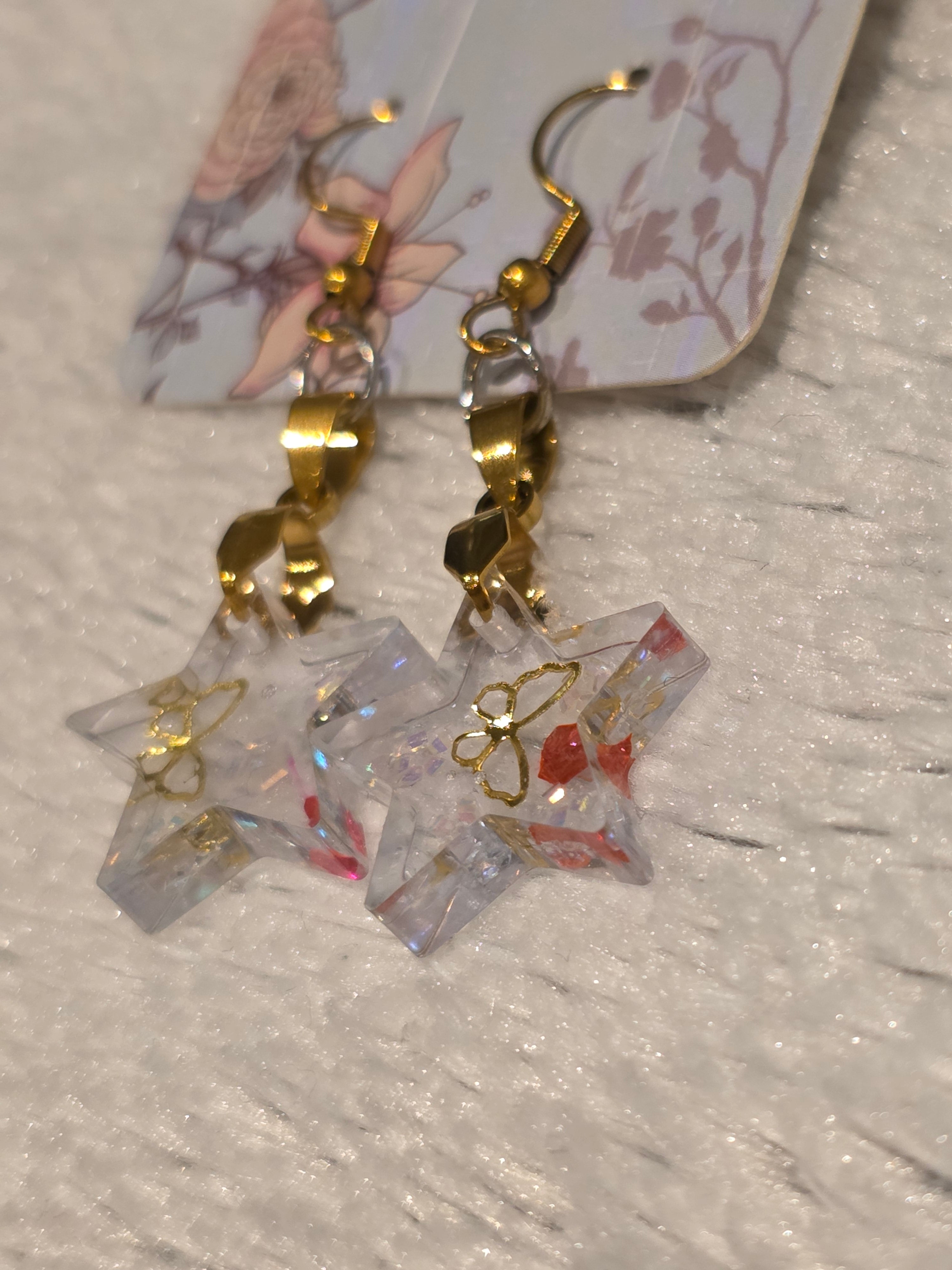Resin earrings – clear star charms with gold detail and glitter effect
