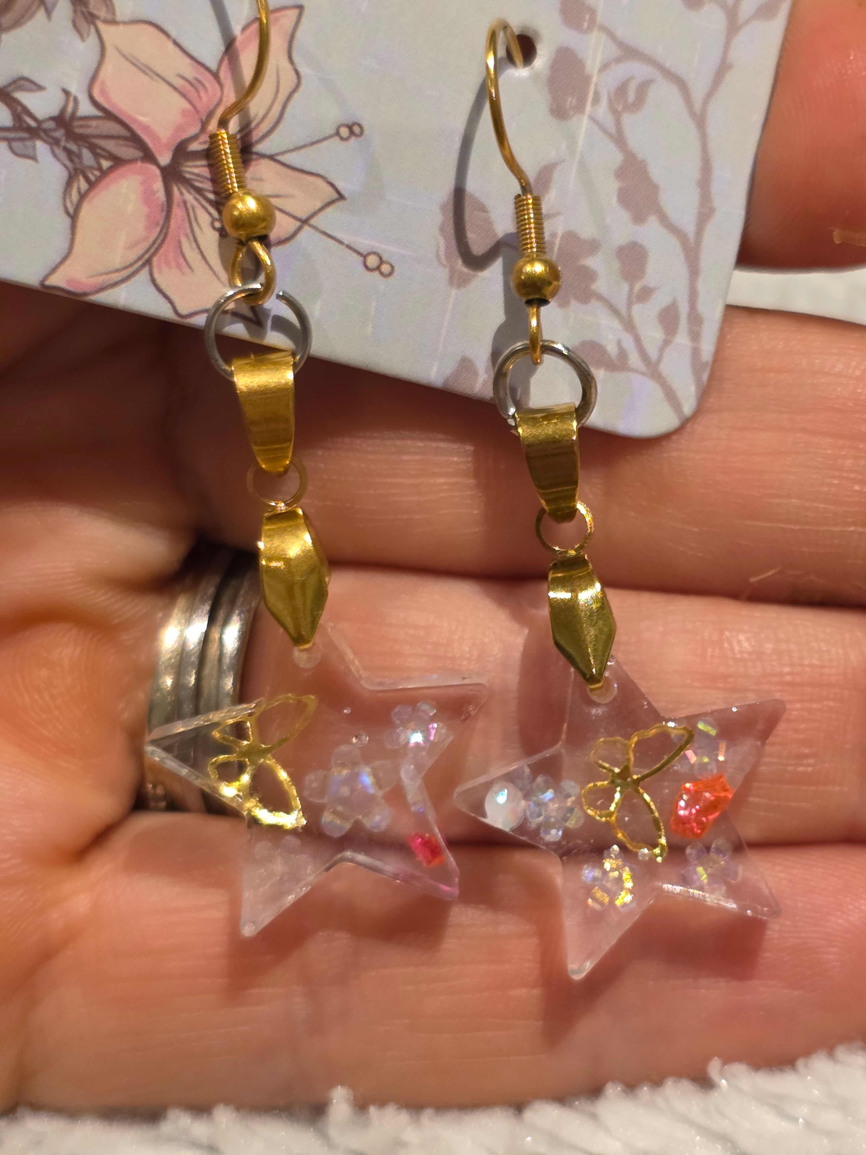 Resin earrings – clear star charms with gold detail and glitter effect