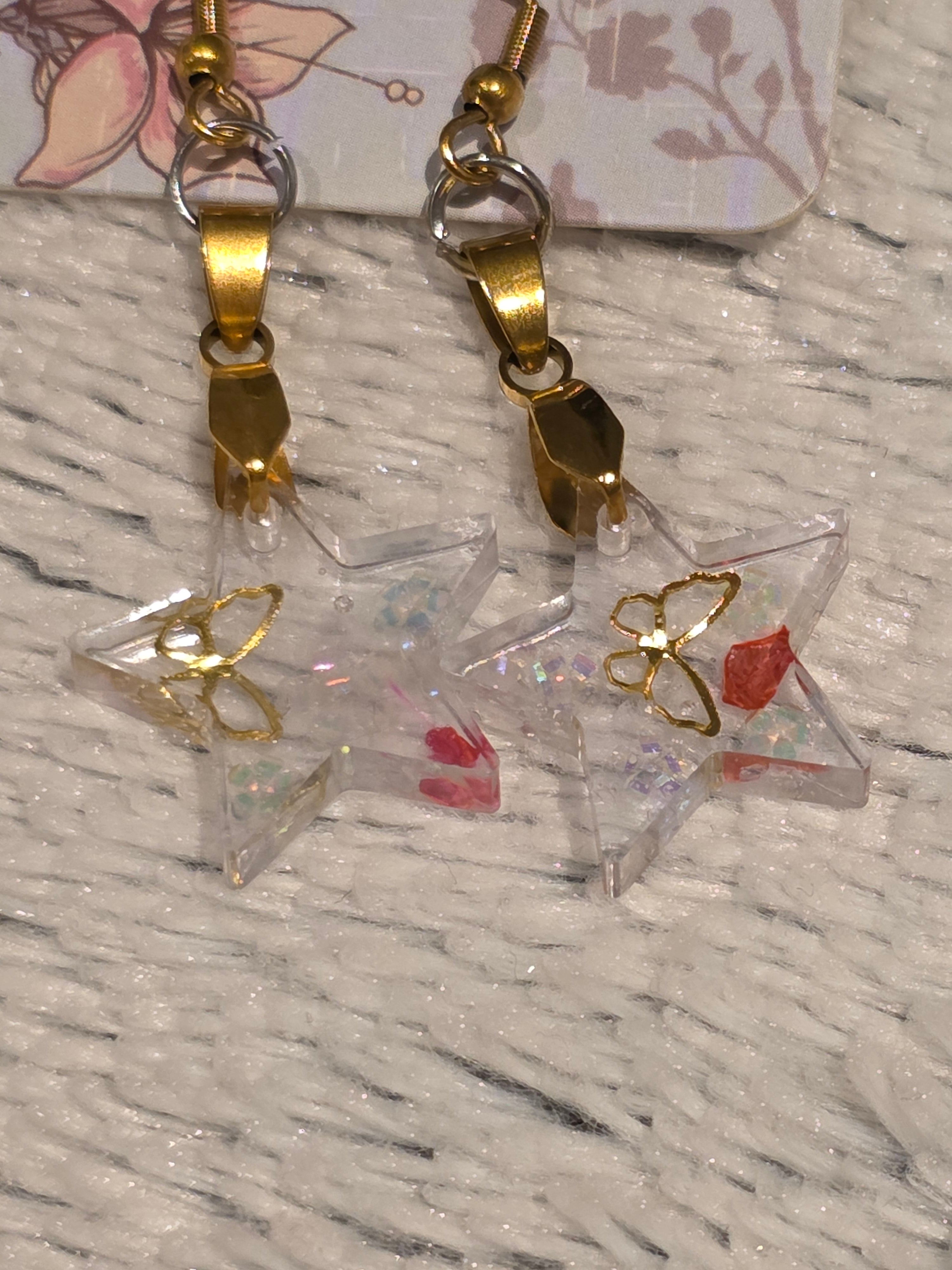 Resin earrings – clear star charms with gold detail and glitter effect