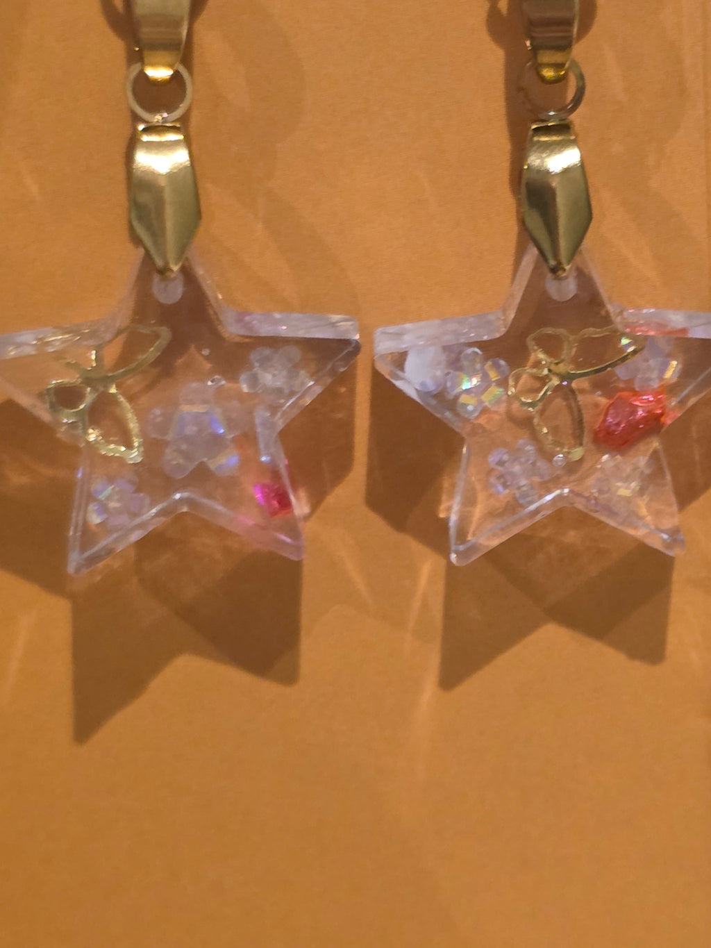Resin earrings – clear star charms with gold detail and glitter effect