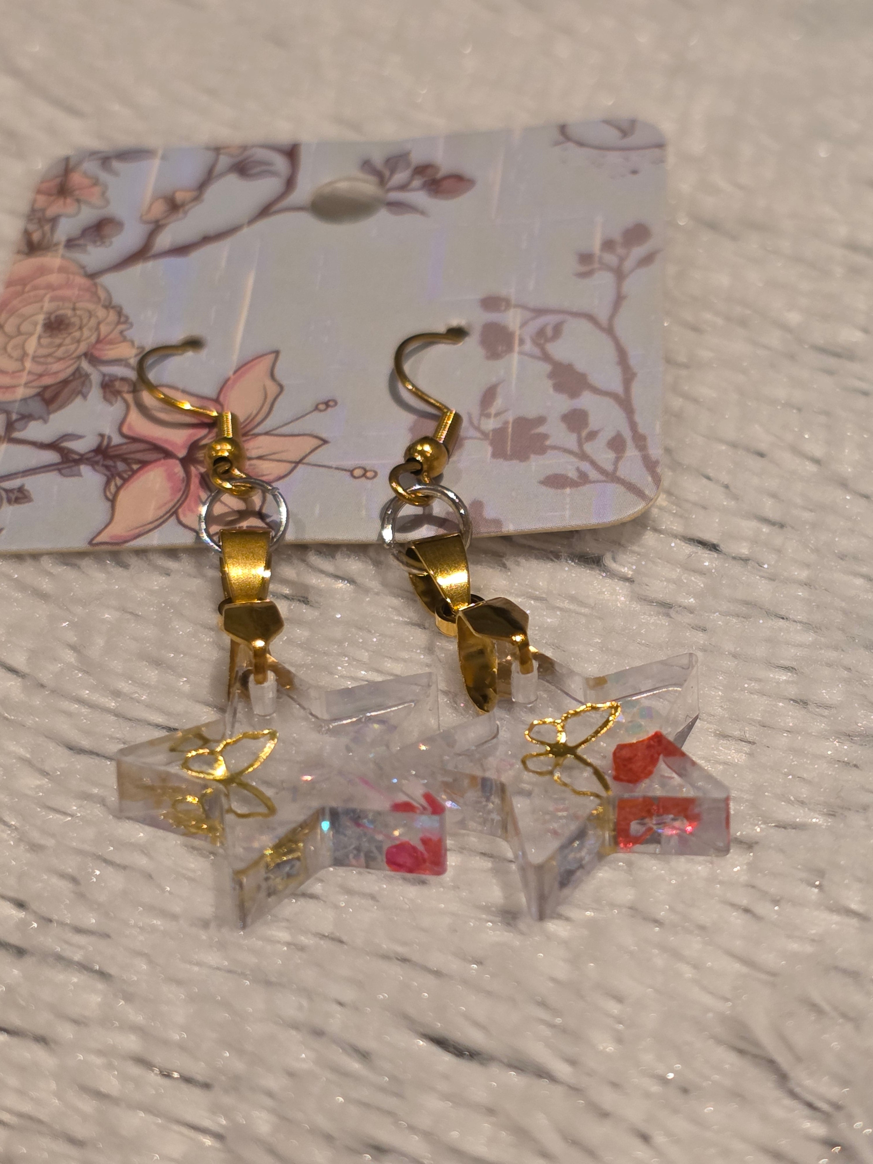 Resin earrings – clear star charms with gold detail and glitter effect